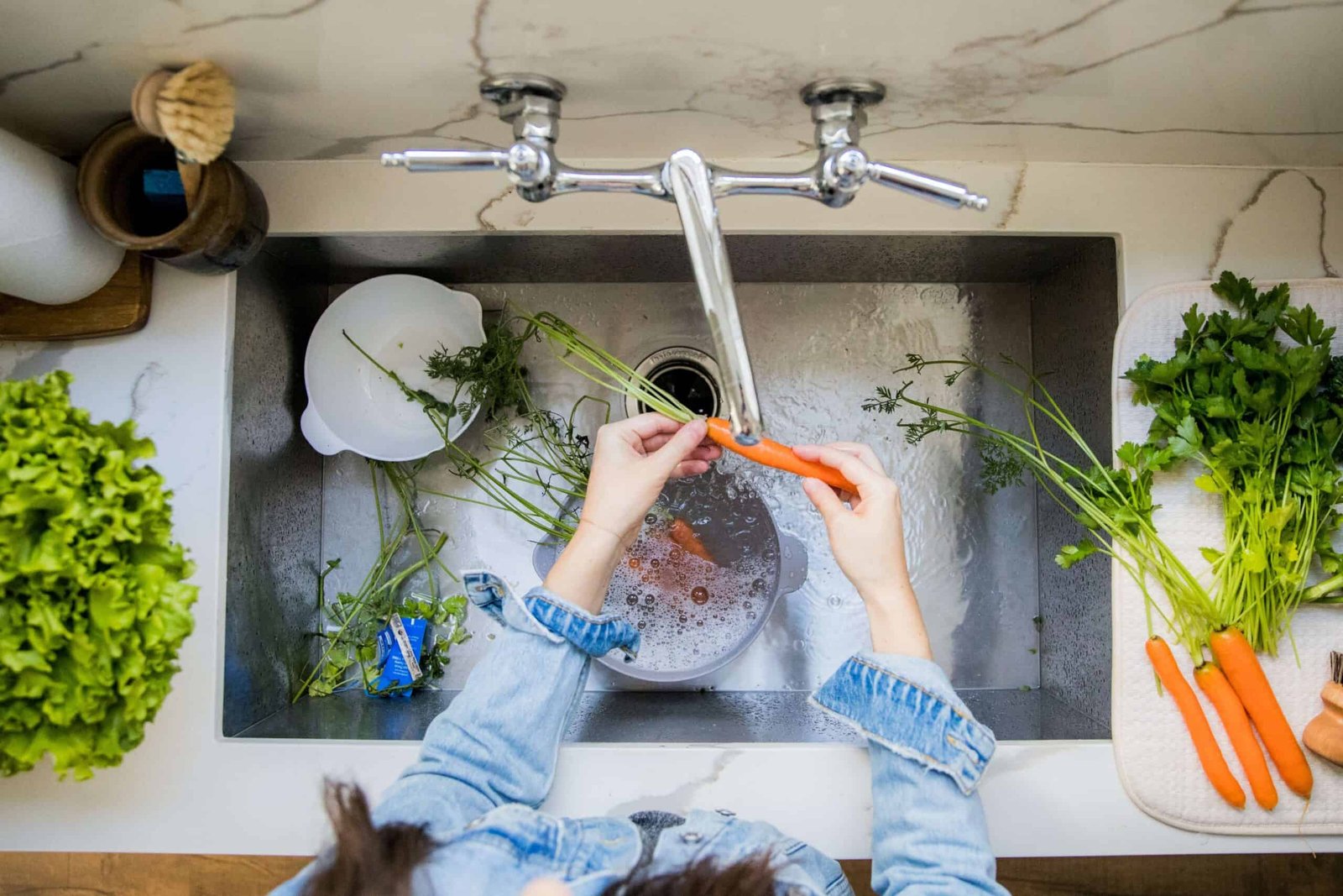 women washing vegetables in sink